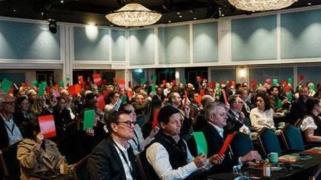 deltakerne på citykonferansen stemmer for stygt eller pent med røde og grønne kort