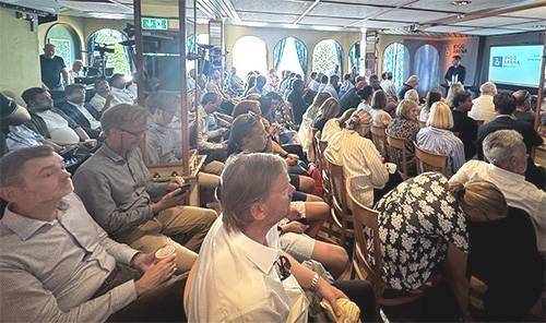 fullsatt møterom med deltagerne fotografert fra siden og foredragsholderen langt fremme